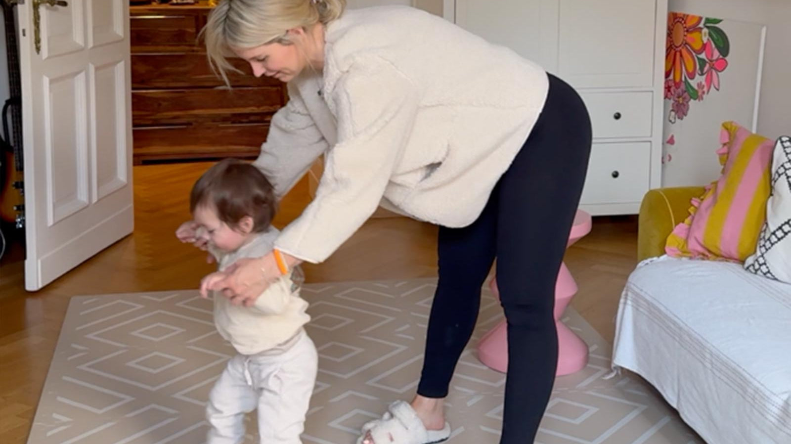 Mother guiding her toddler’s first steps on an Eeveve EVA foam play mat in a bright, modern living space.