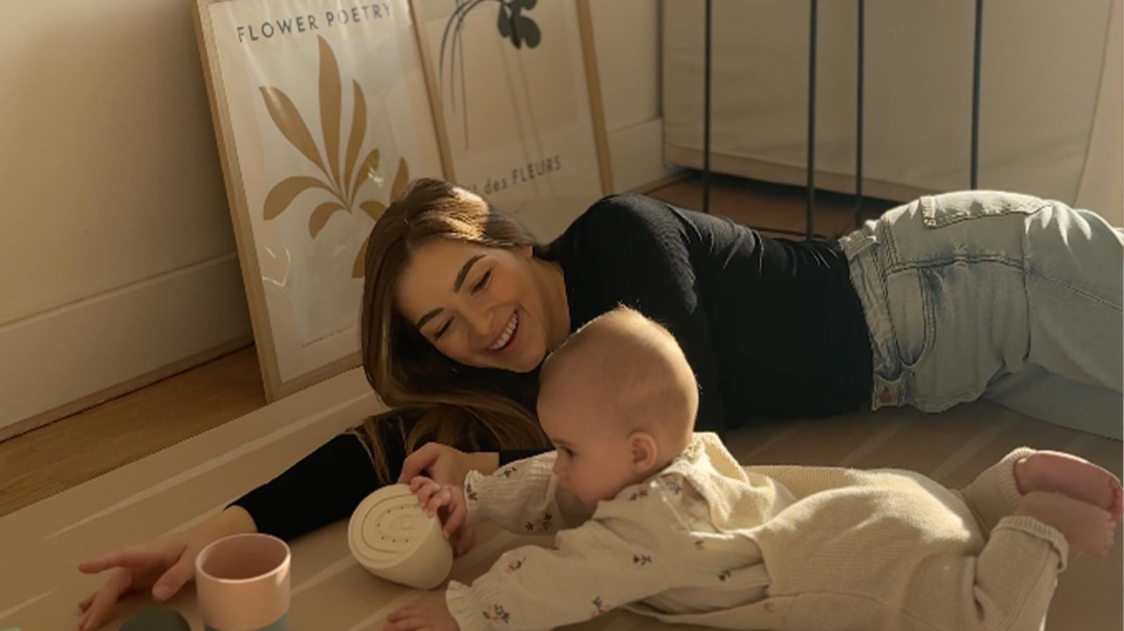Mother lying on an Eeveve play mat with her baby during tummy time.