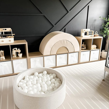 Lucio play mat in linen color by Eeveve, styled in a modern playroom with wooden toys and neutral decor. EVA foam that meets US and EU toy safety standards for safe play.