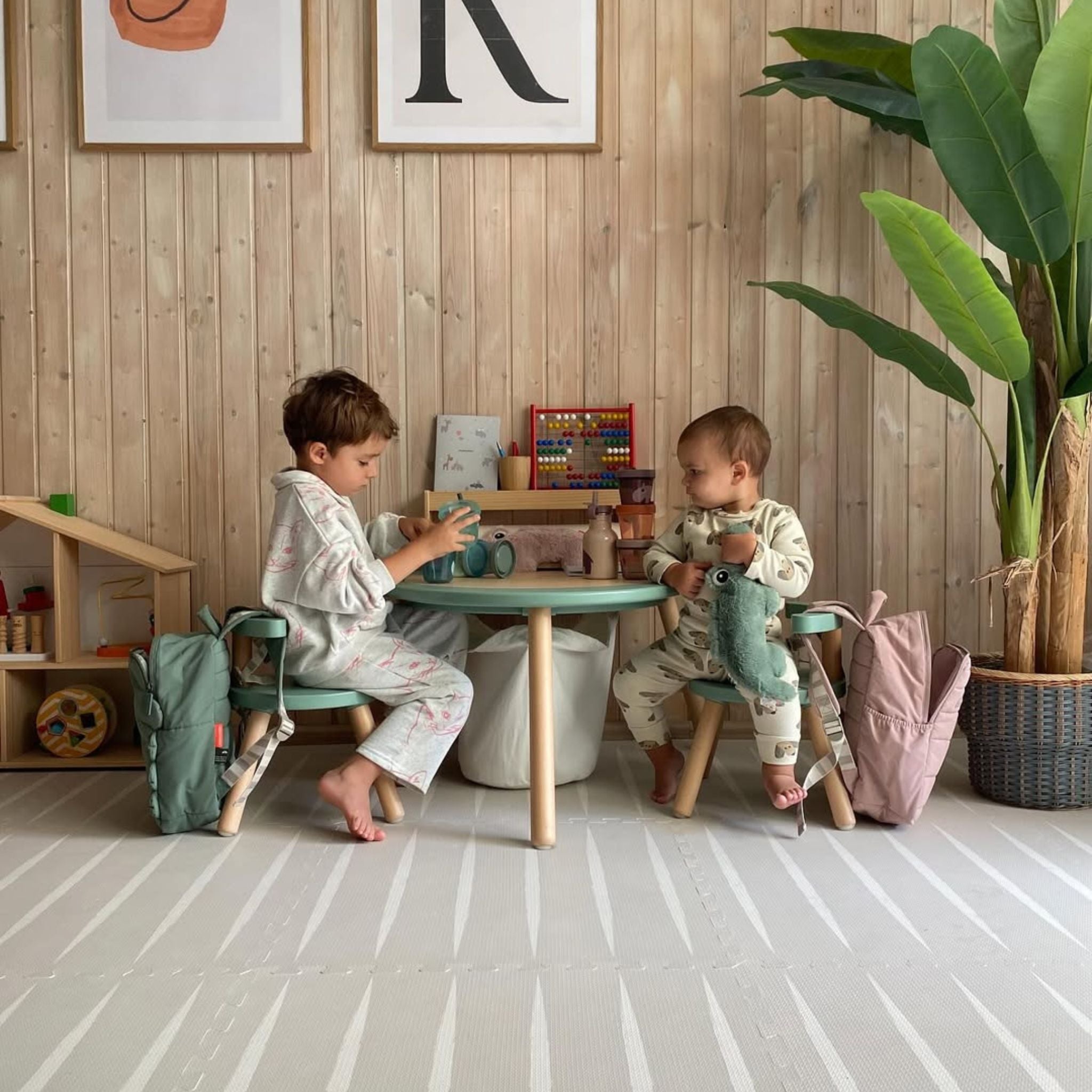 Two toddlers playing on the Lucio play mat by Eeveve in a cozy playroom. Non-toxic and stylish EVA foam mat for safe indoor fun.