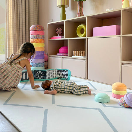 Children playing on the Beni Powder Blue play mat by Eeveve, ideal for tummy time and safe floor play in a stylish nursery setting.