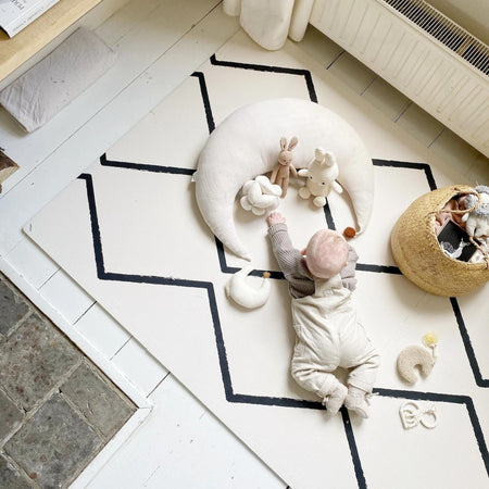 Baby during tummy time on Eeveve Beni - Ecru foam play mat surrounded by soft toys, ideal for early developmental stages.