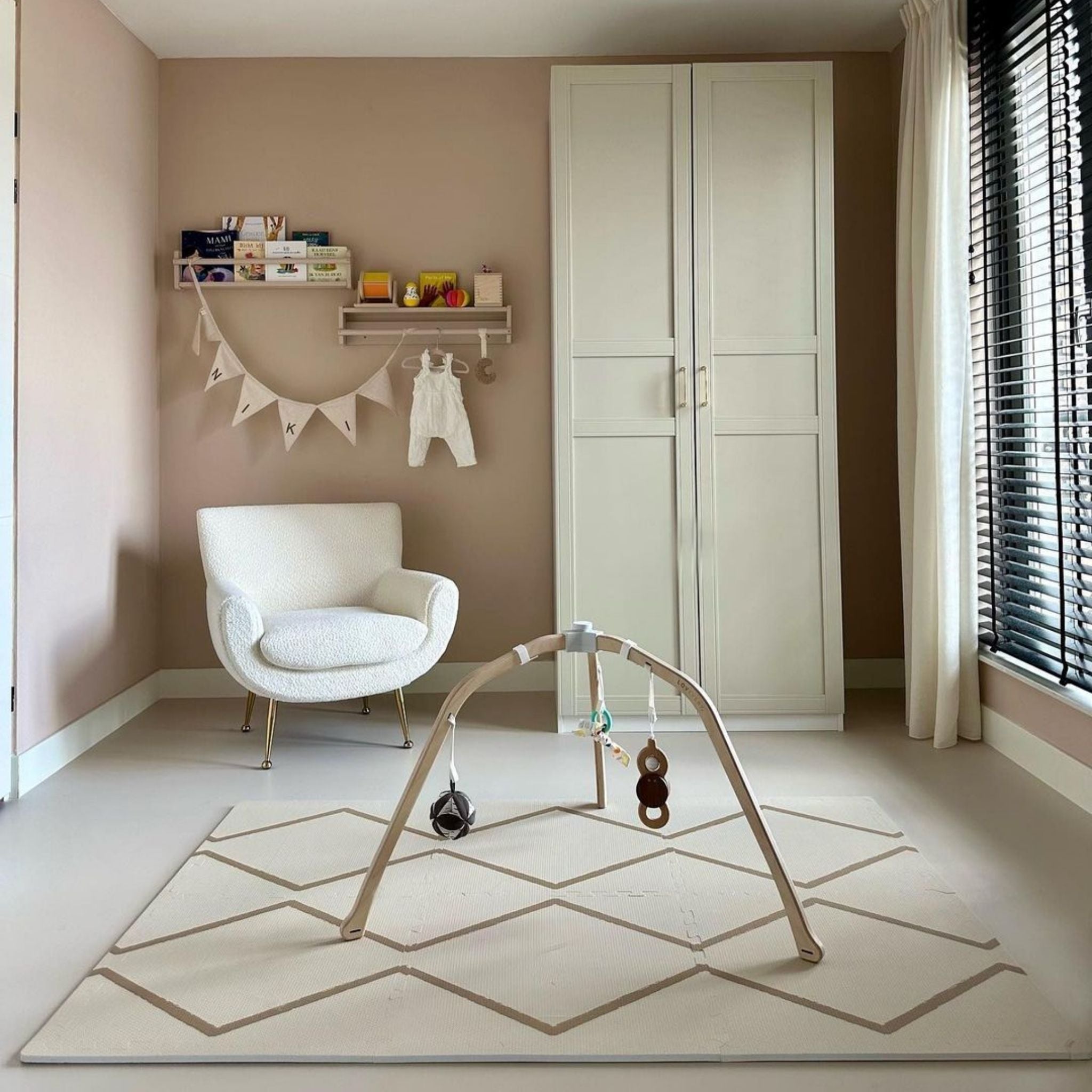 Minimalist nursery with Beni - Autumn Gold - Play Mat by Eeveve under a baby gym, providing a cushioned and safe play surface for infants.