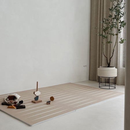 Lucio Desert Sand Play Mat laid out in minimalist room with wooden toys, emphasizing stylish and safe play area.