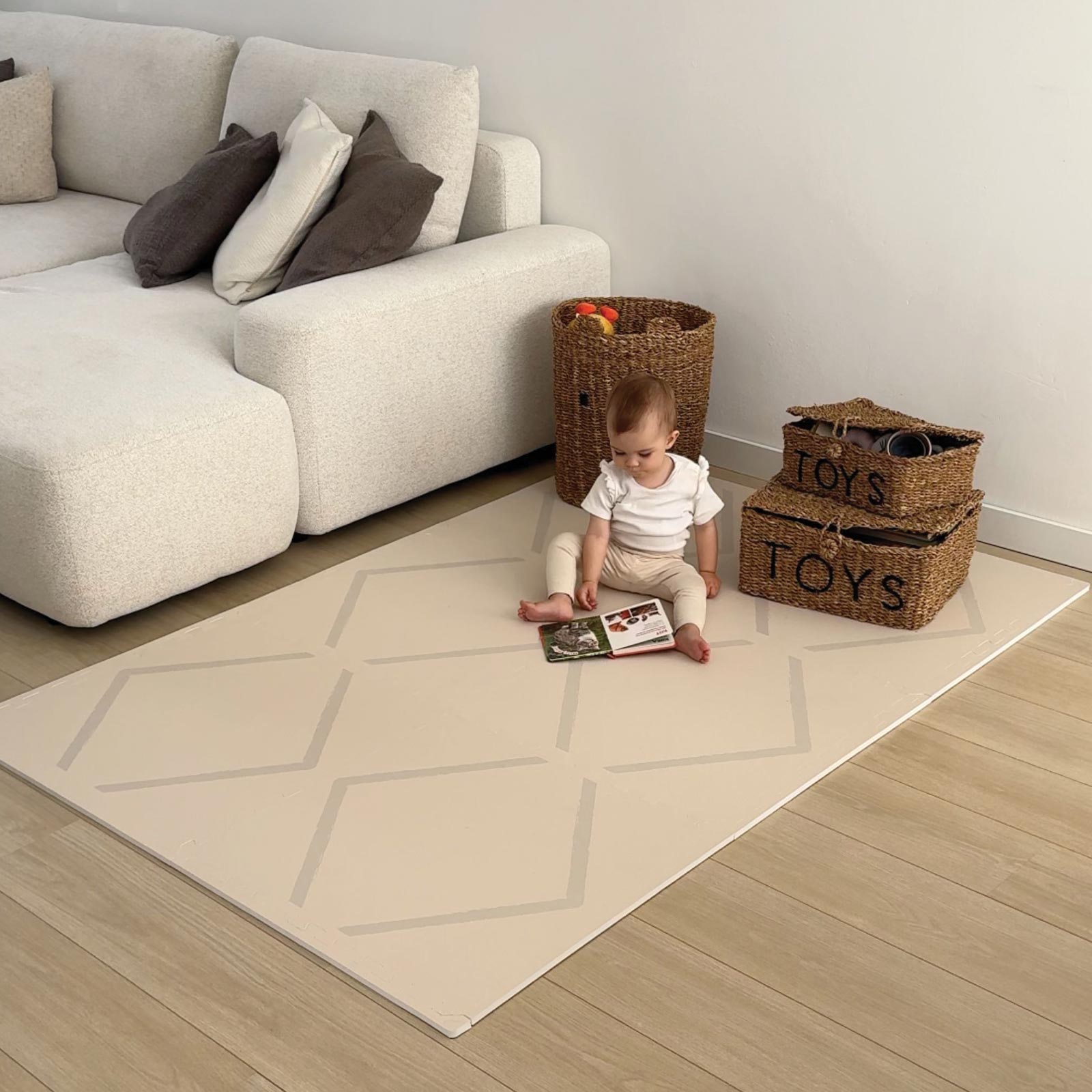 Baby sitting on an Eeveve Beni Cashmere play mat in a modern living room.