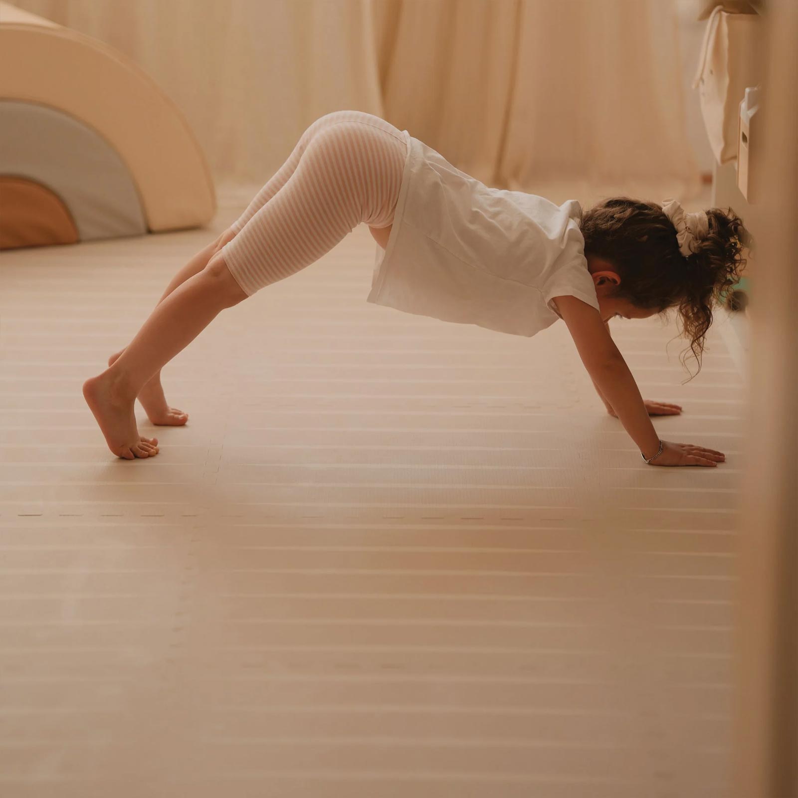 Child practicing yoga on an Eeveve Lucio Linen play mat.