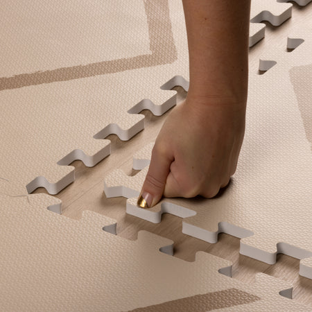 Hand pressing interlocking edge of Beni - Autumn Gold - Play Mat, showing soft, thick EVA foam texture and easy assembly design by Eeveve.
