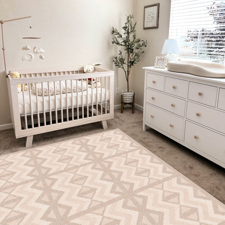 Kilim Sand Play Mat by Eeveve in a neutral-toned nursery with crib and dresser. EVA foam mat ideal for baby play and tummy time.