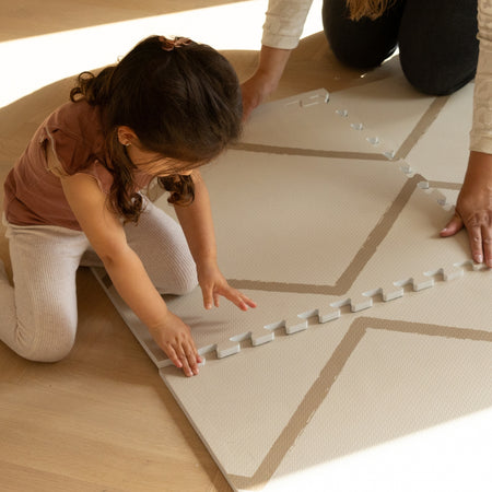 Toddler assembling Beni - Autumn Gold - Play Mat by Eeveve, a soft EVA foam puzzle mat ideal for baby development and safe playtime.