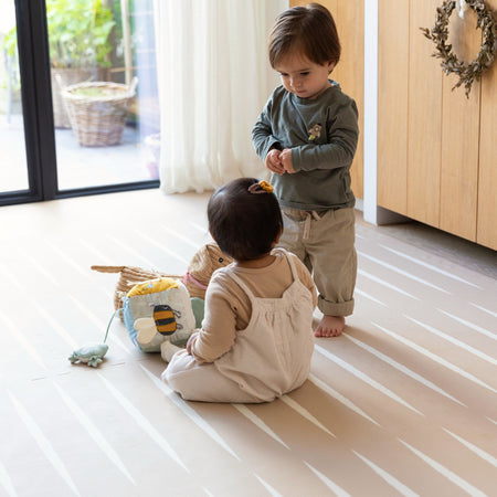 Two toddlers interacting on Lucio Desert Sand Play Mat, ideal for crawling and playtime on soft foam surface.